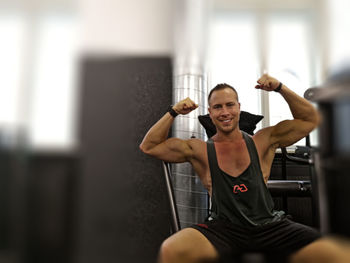Portrait of smiling young man with arms raised