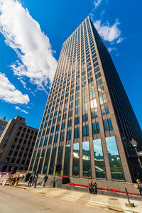 Low angle view of modern building against cloudy sky