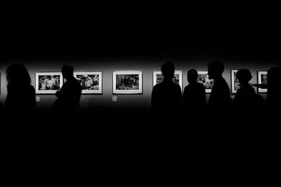 Silhouette people standing in dark room