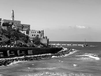 View of buildings by sea against sky