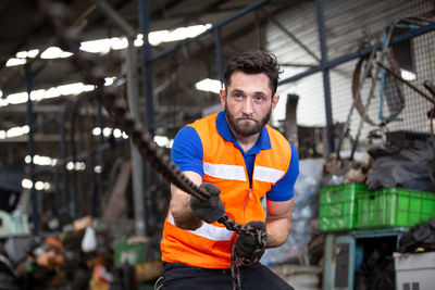 Worker pulling metallic chain at factory