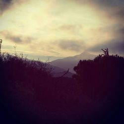 Scenic view of mountains against cloudy sky