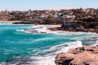 Scenic view of sea and cityscape against sky