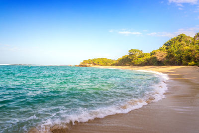 Scenic view of beach against sky on sunny day