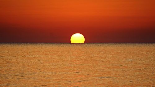 Scenic view of sea against romantic sky at sunset