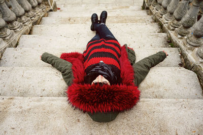 High angle view of woman lying down on staircase