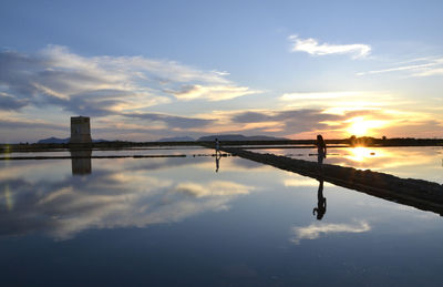 Reflection of bridge in river during sunset