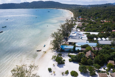 High angle view of trees and buildings by sea