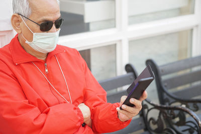 Midsection of man using mobile phone