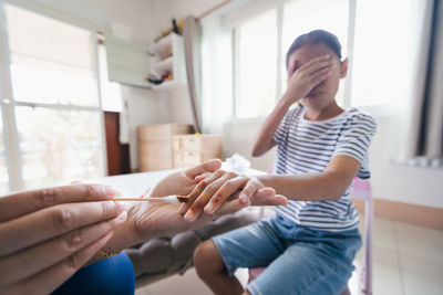 Asian child girl feeling scared while parent helping her perform first aid finger injury.