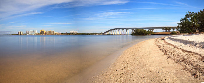 Bridge over river in city against sky