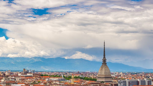 View of cityscape against cloudy sky