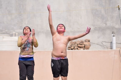 Young couple standing against wall