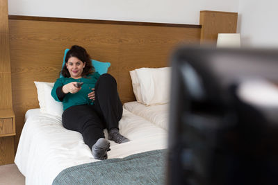 Full length of woman sitting on sofa