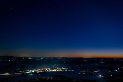 Aerial view of illuminated city against sky at night