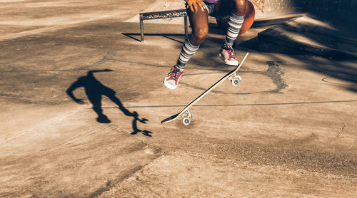 Low section of men playing with skateboard