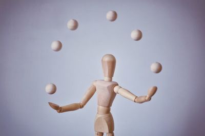 Wooden figurine and balls against white background