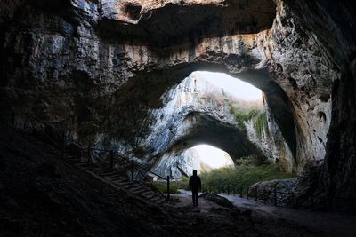 Rear view of man standing in cave