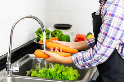 Midsection of man preparing food in kitchen at home