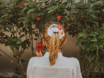 Rear view of woman standing by plants