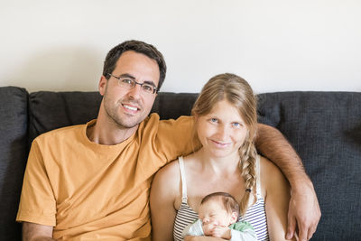 Portrait of smiling family sitting on sofa