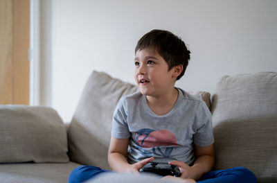 Boy sitting on sofa at home