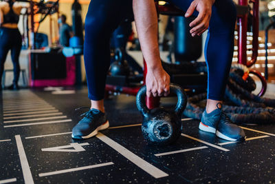 Low section of young muscular man working out with a dumbbell 