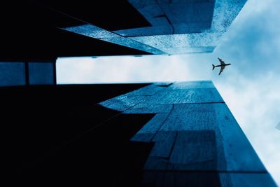 Low angle view of airplane flying against sky