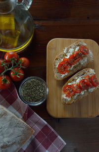 Bruschetta with cherry tomatoes, feta cheese ,olive oil,garlic and thyme on wooden board