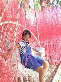 Full length portrait of girl sitting outdoors