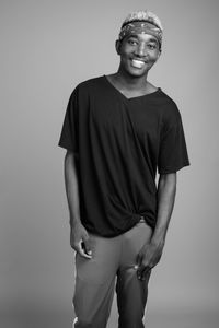 Young man standing against gray background