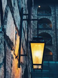 Close-up of illuminated street light on wall