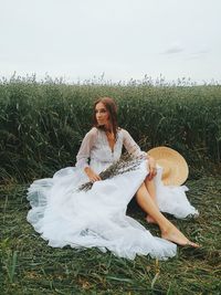 Portrait of a smiling young woman sitting on field