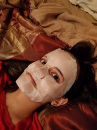 High angle portrait of woman lying on bed