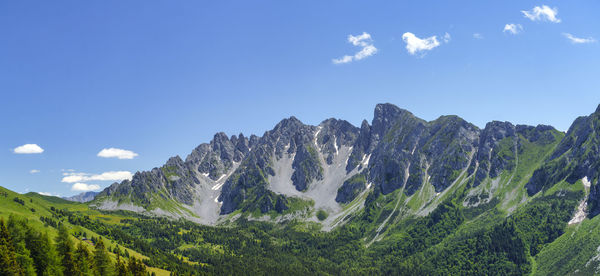 Panoramic view of landscape and mountains against blue sky