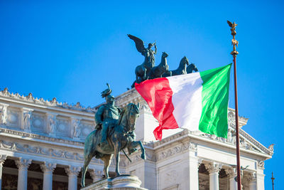 Low angle view of statues against blue sky