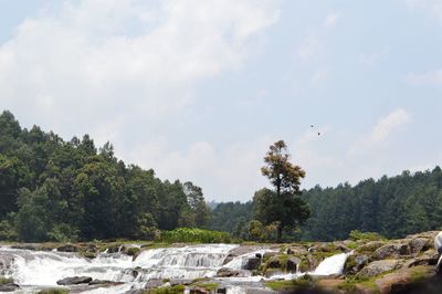 Scenic view of waterfall against sky