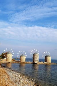 Buildings by sea against sky