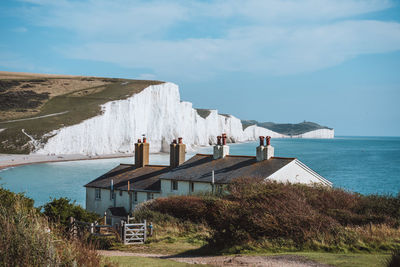 Built structure on beach by buildings against sky