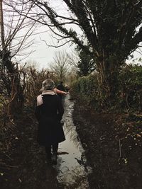 Rear view of woman walking in forest