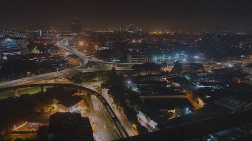 High angle view of illuminated cityscape against sky at night