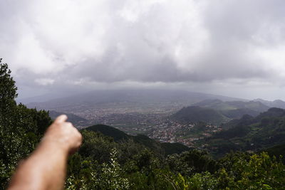 Midsection of person on mountain against sky