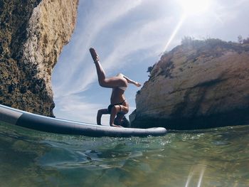 Full length of man on rock formation against sky