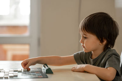 Close-up of boy using calculator at home