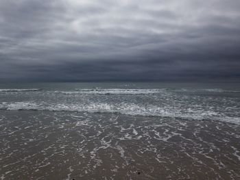 Scenic view of sea against storm clouds