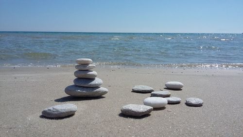 Stack of stones on beach against clear sky