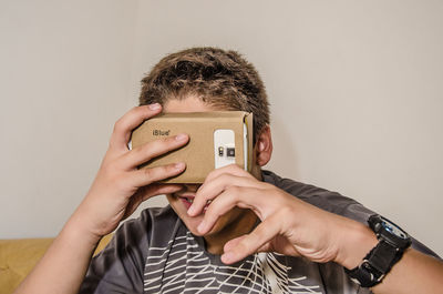 Boy watching virtual reality against gray background