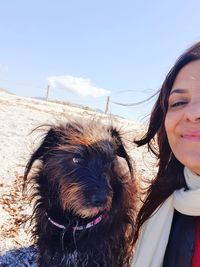 Woman with dog against sky