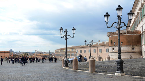 People on street against buildings in city