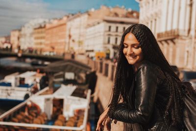 Smiling young woman standing in city